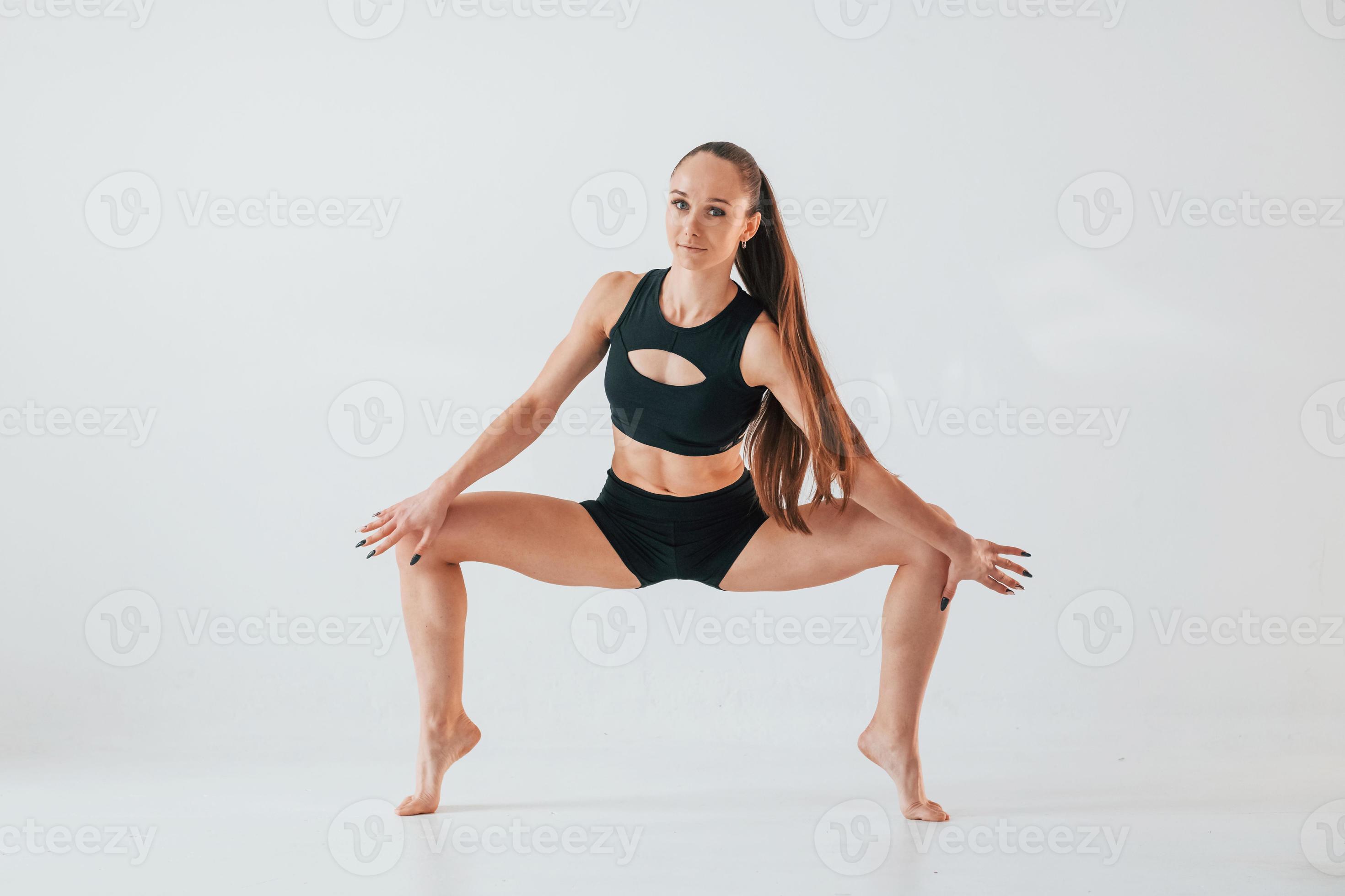 Exercises for stretch and strength. Young woman in sportive clothes doing  gymnastics indoors 15458166 Stock Photo at Vecteezy