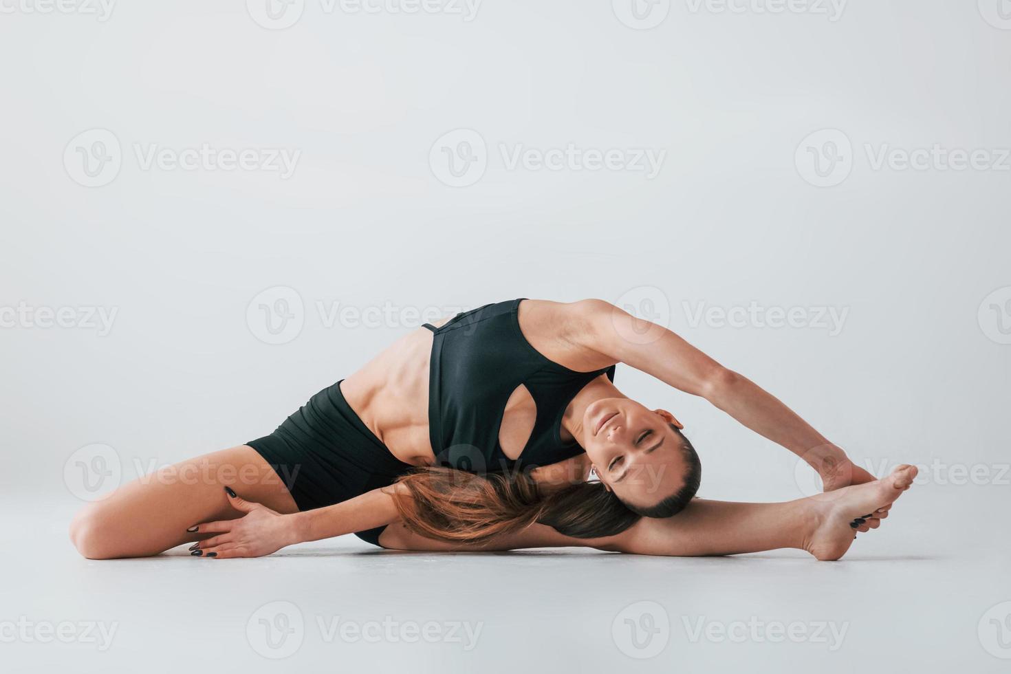 Focused on the exercises. Young woman in sportive clothes doing gymnastics indoors photo