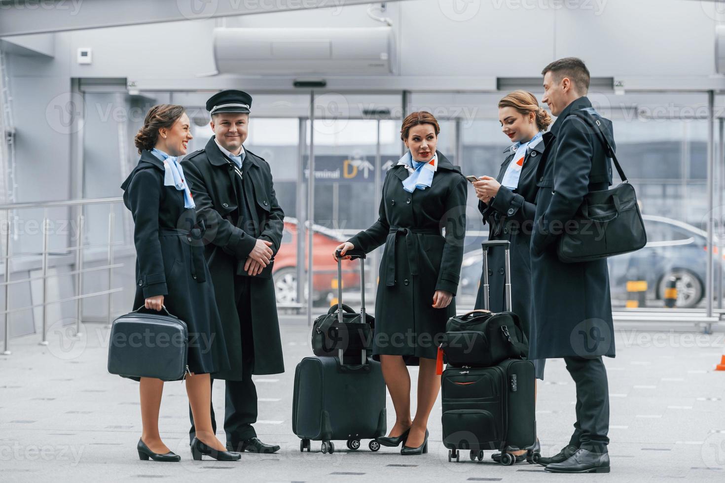 Aircraft crew in work uniform is together outdoors in the airport photo