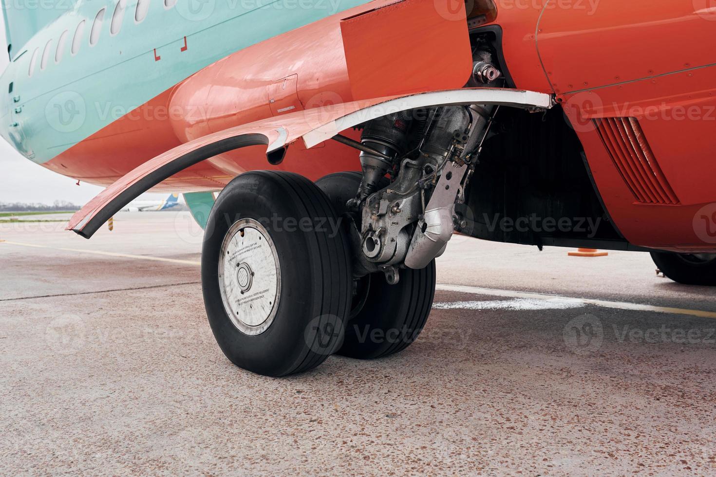 Close up view of wheels. Turboprop aircraft parked on the runway at daytime photo