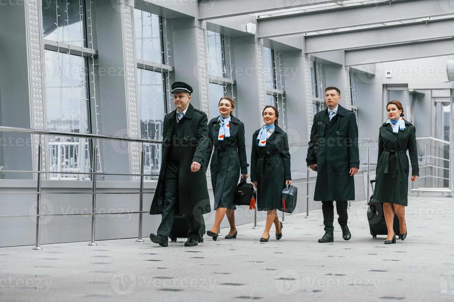 la tripulación del avión con uniforme de trabajo está junta al aire libre en el aeropuerto foto