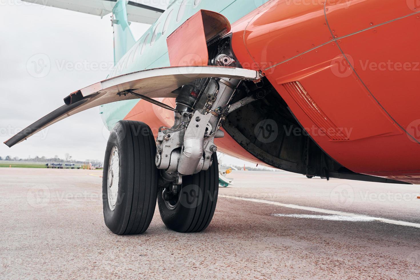 vista de cerca de las ruedas. avión turbohélice estacionado en la pista durante el día foto