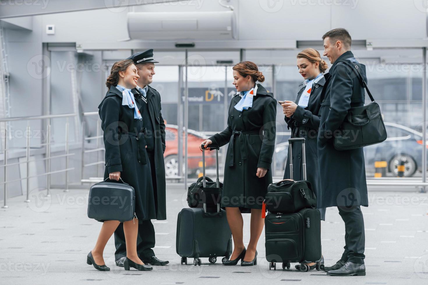 Aircraft crew in work uniform is together outdoors in the airport photo