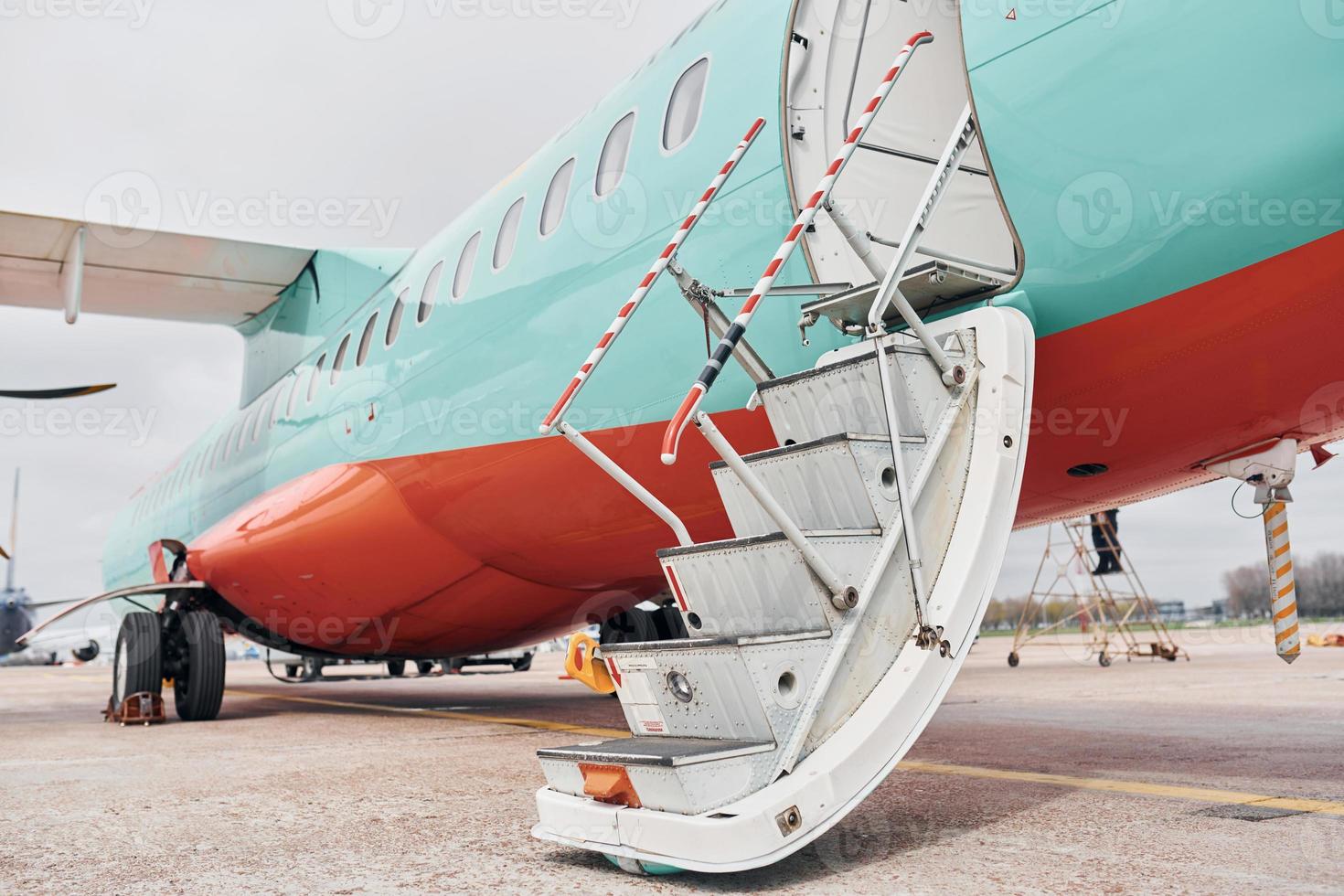 las puertas están abiertas. avión turbohélice estacionado en la pista durante el día foto