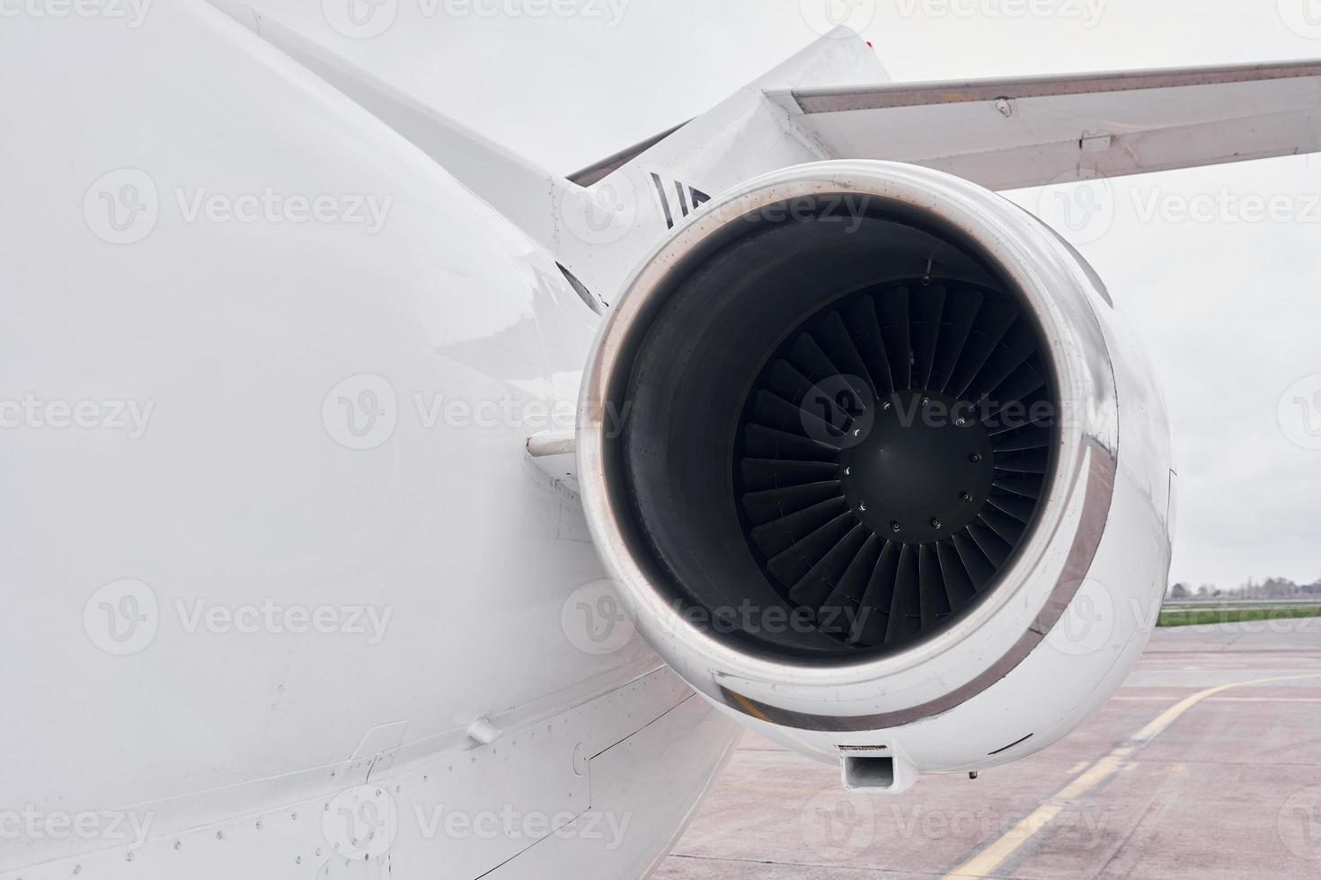 Close up view. Turboprop aircraft parked on the runway at daytime photo