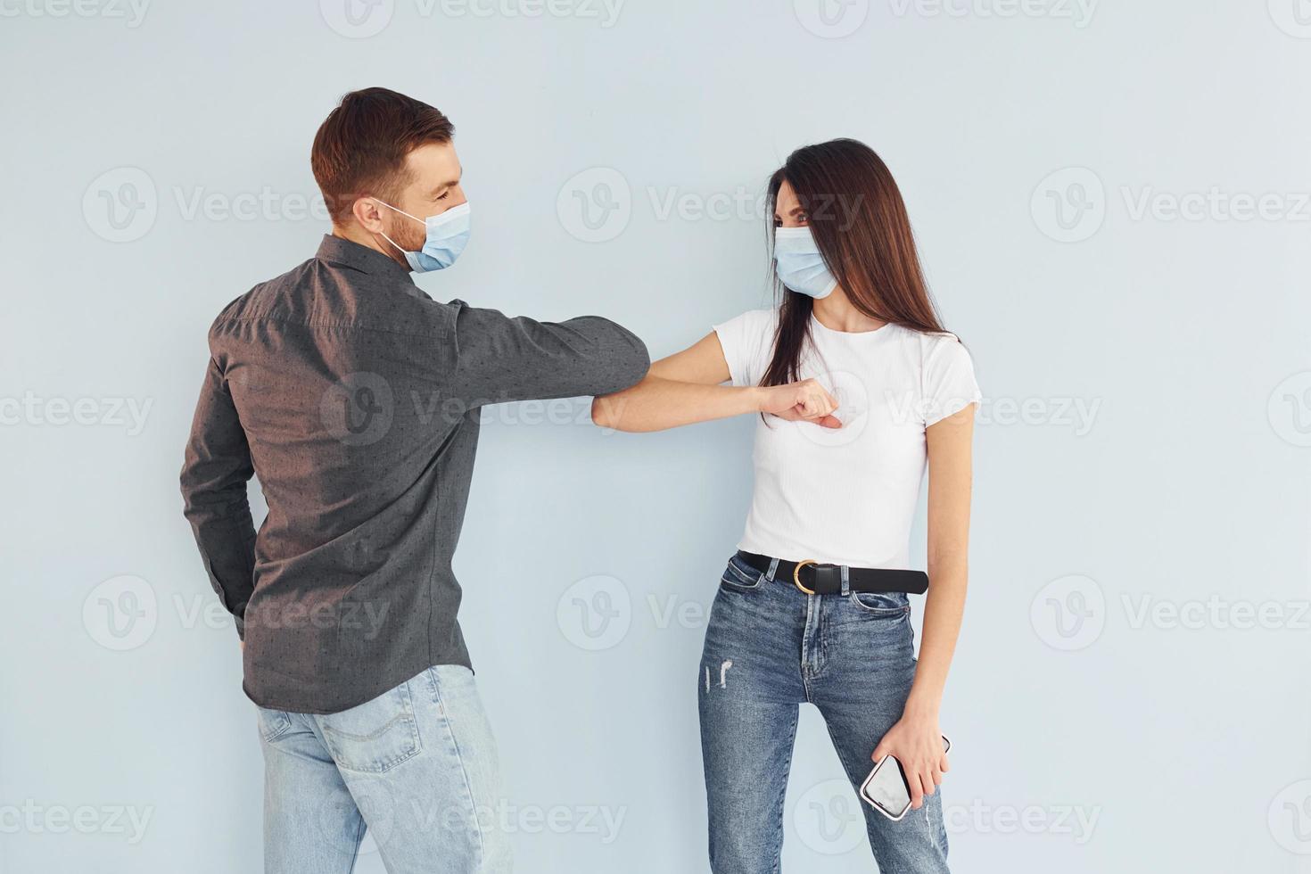 Man and woman standing indoors in the studio against white background photo