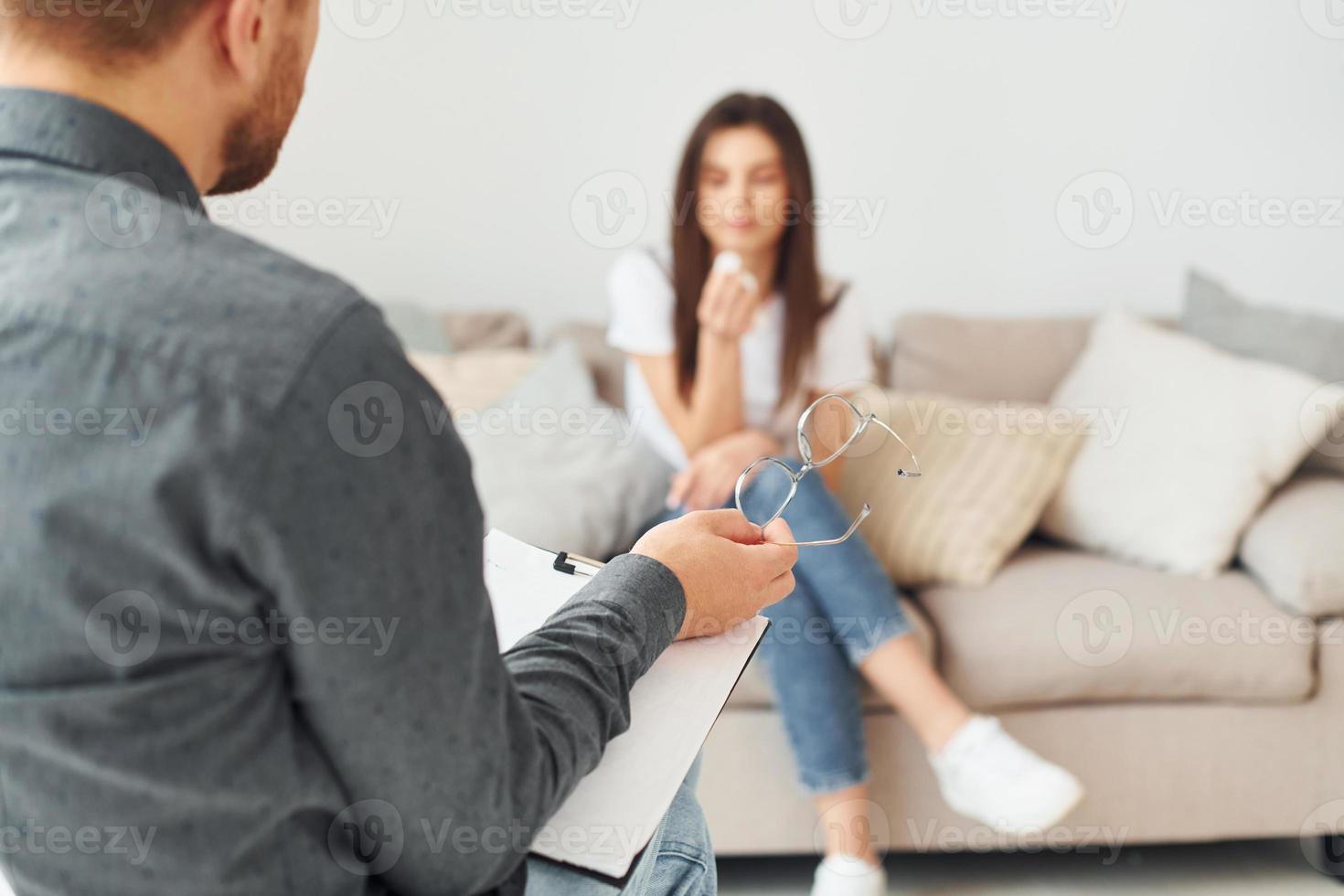 Young woman at a reception at a psychologist. Sits on the sofa photo