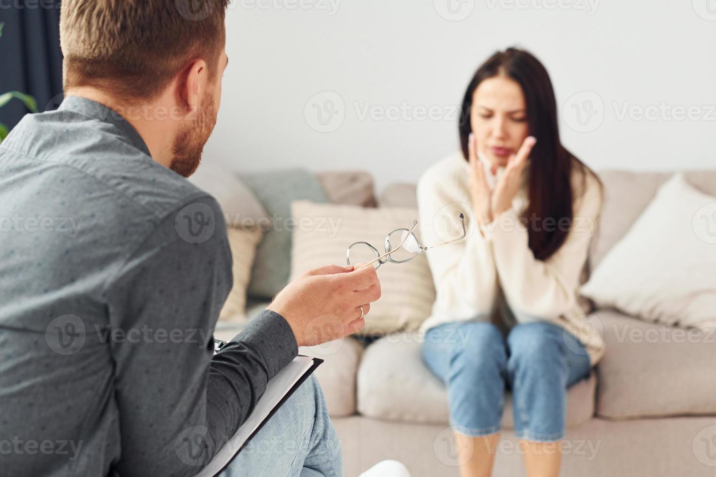 Young woman at a reception at a psychologist. Sits on the sofa photo