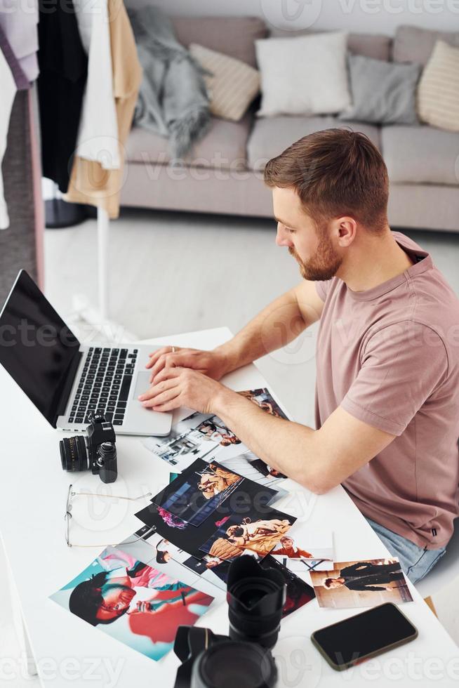 el fotógrafo con ropa informal está trabajando en el interior durante el día foto