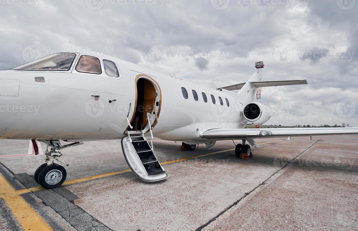 Cloudy weather. Turboprop aircraft parked on the runway at daytime photo