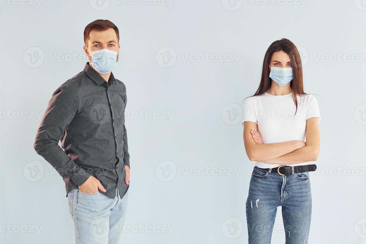 Man and woman standing indoors in the studio against white background photo