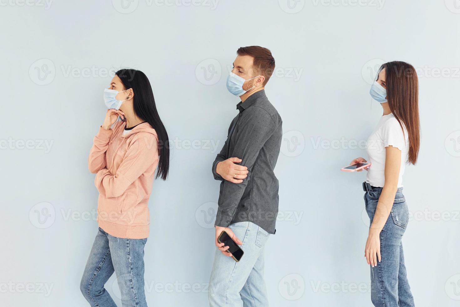 tres personas de pie juntas en el estudio con fondo blanco foto