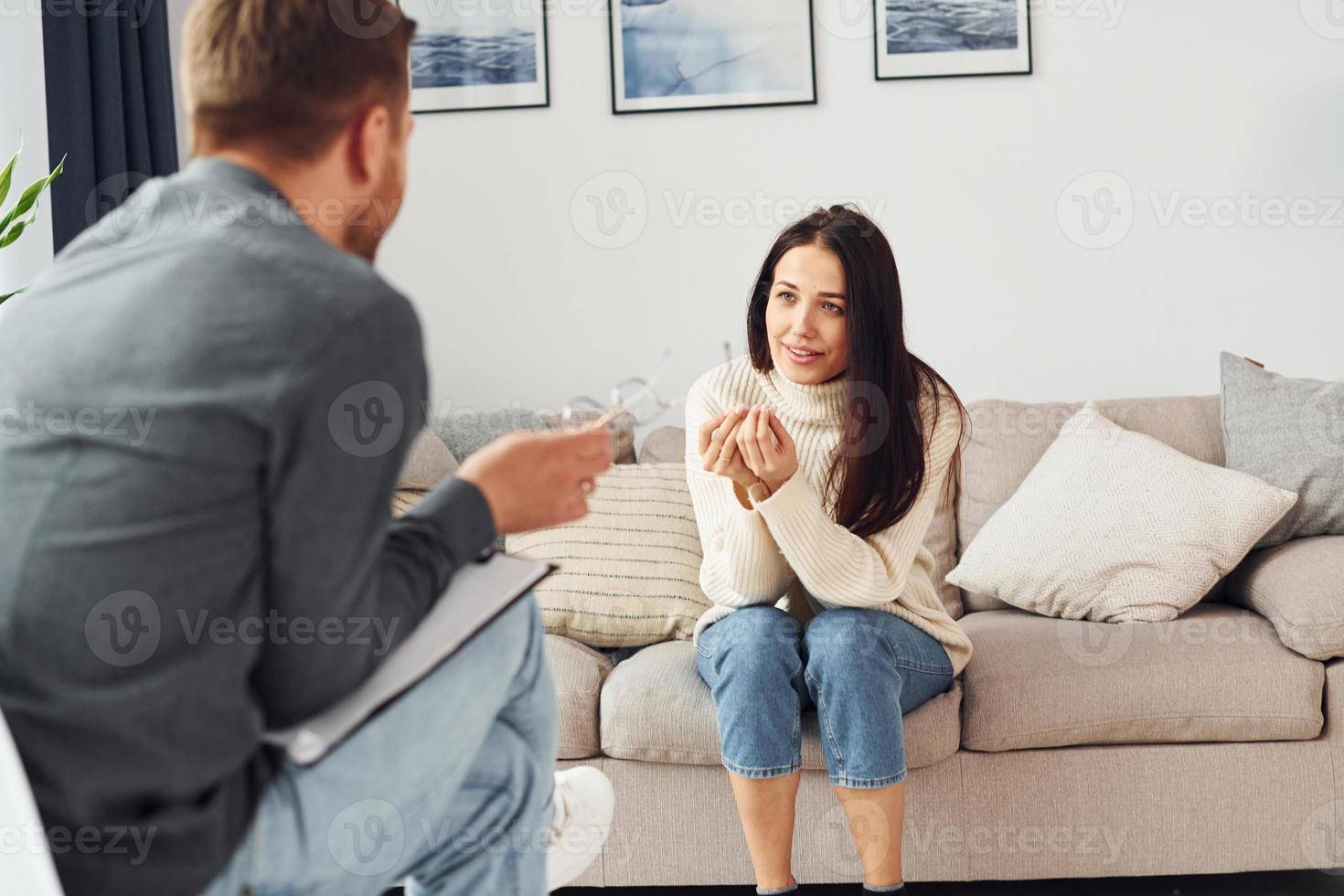 Young woman at a reception at a psychologist. Sits on the sofa photo