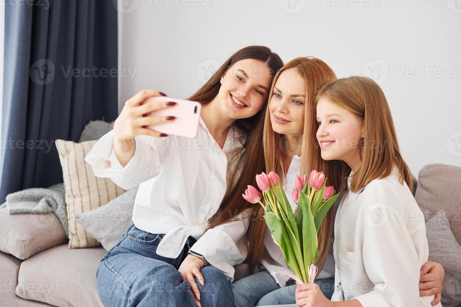 sentado con regalos. joven madre con sus dos hijas en casa durante el día foto