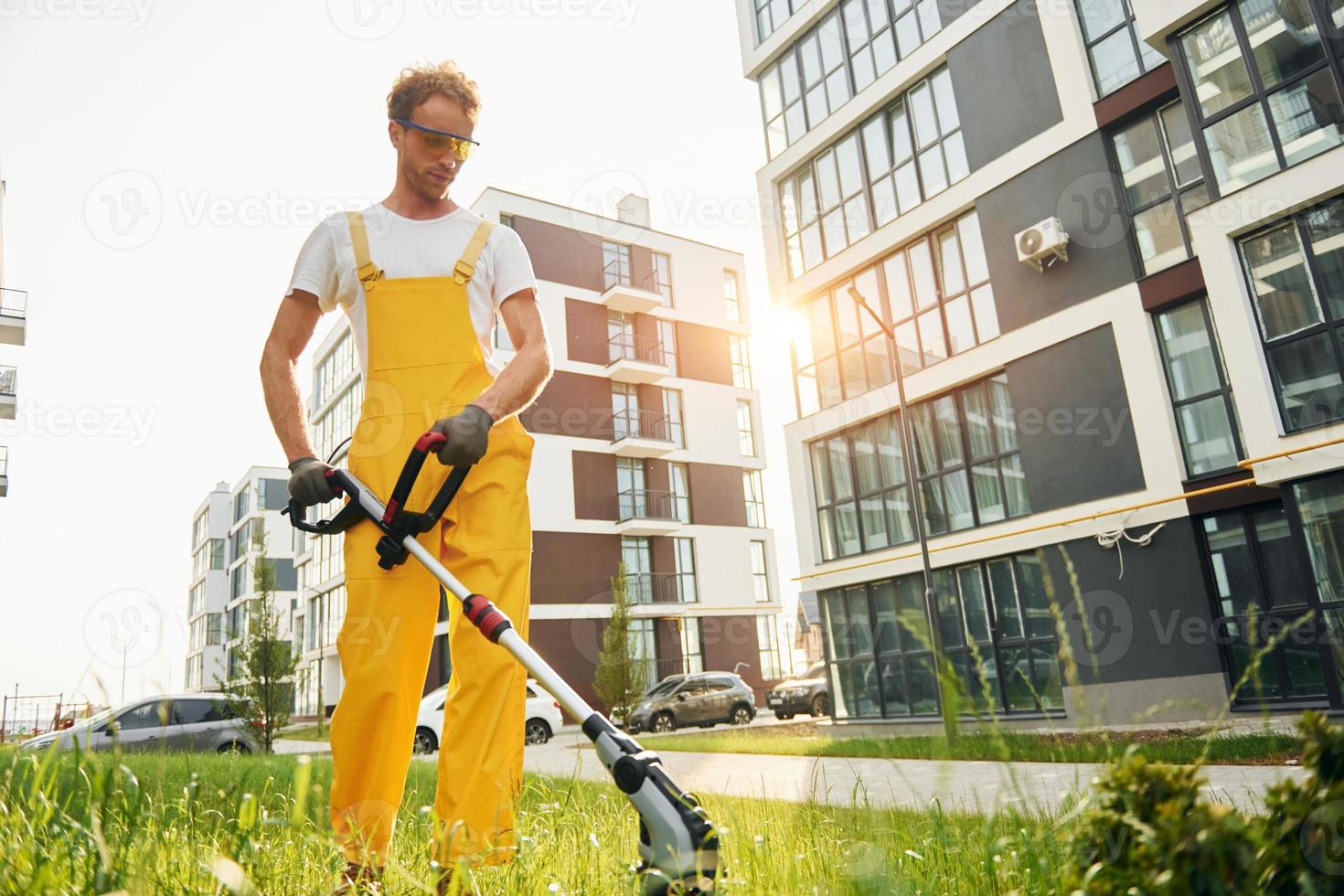 One person. Man cut the grass with lawn mover outdoors in the yard photo
