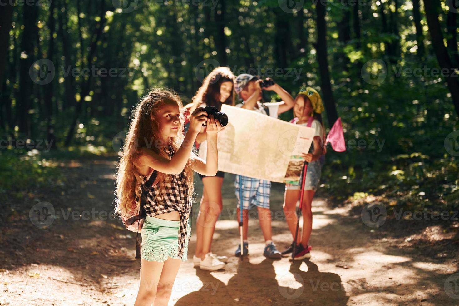 With touristic equipment. Kids strolling in the forest photo