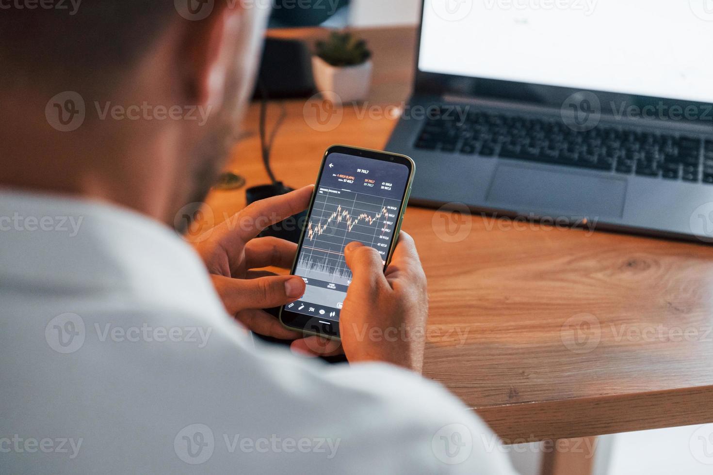 Graphs and diagrams. Young businessman in formal clothes is in office with multiple screens photo