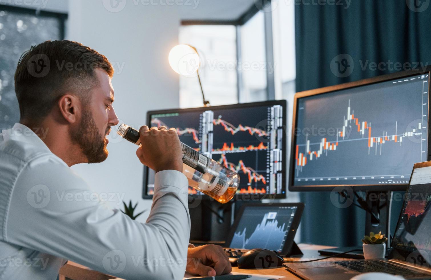 Conception of failure. Young businessman in formal clothes is in office with multiple screens photo