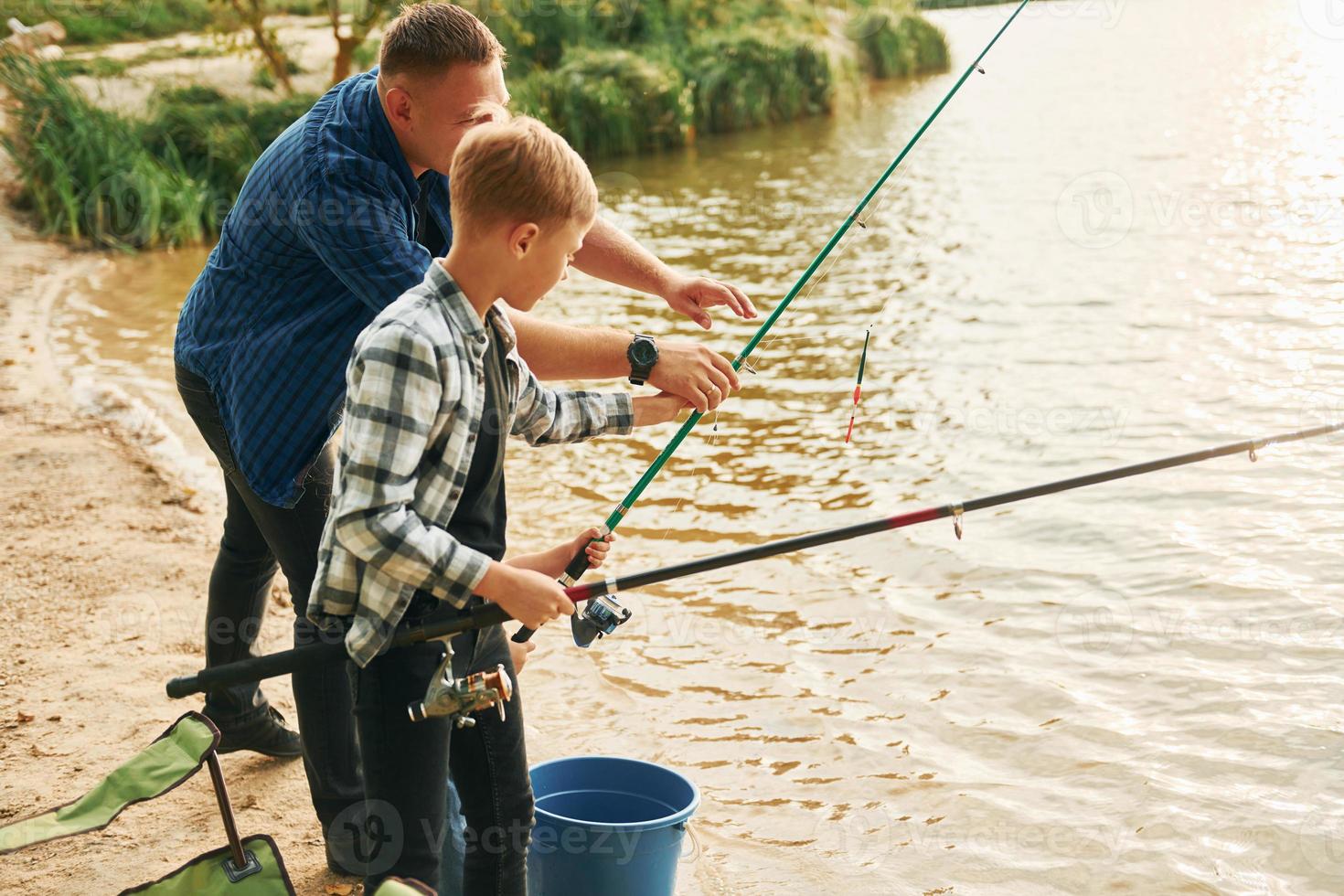 Resting and having fun. Father and son on fishing together outdoors at summertime photo