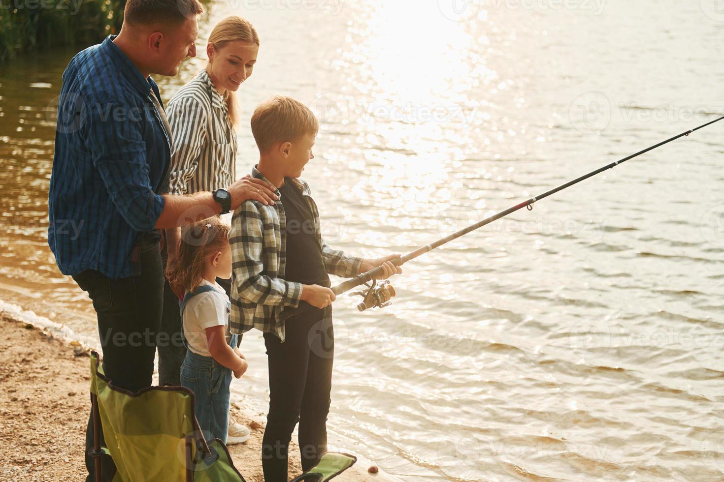 Conception of vacation. Father and mother with son and daughter on fishing  together outdoors at summertime 15459145 Stock Photo at Vecteezy