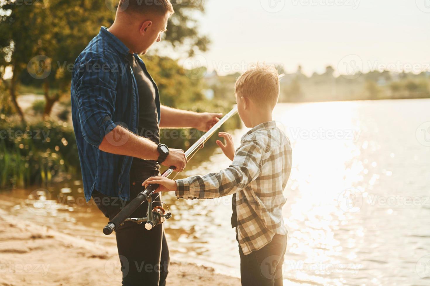 Father and son on fishing together outdoors at summertime photo