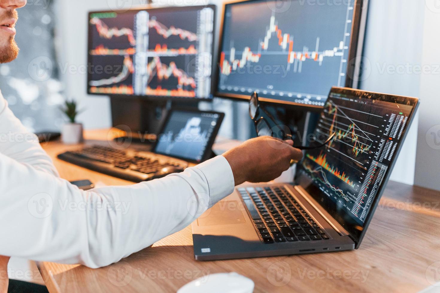 Analyzing information. Young businessman in formal clothes is in office with multiple screens photo