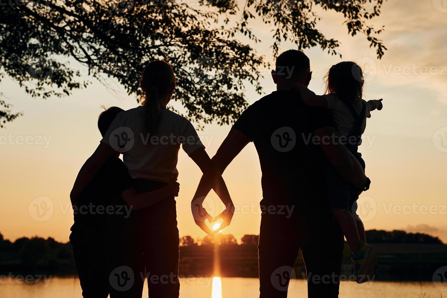 Looking at sunset. Family of mother, father and kids is on the camping photo