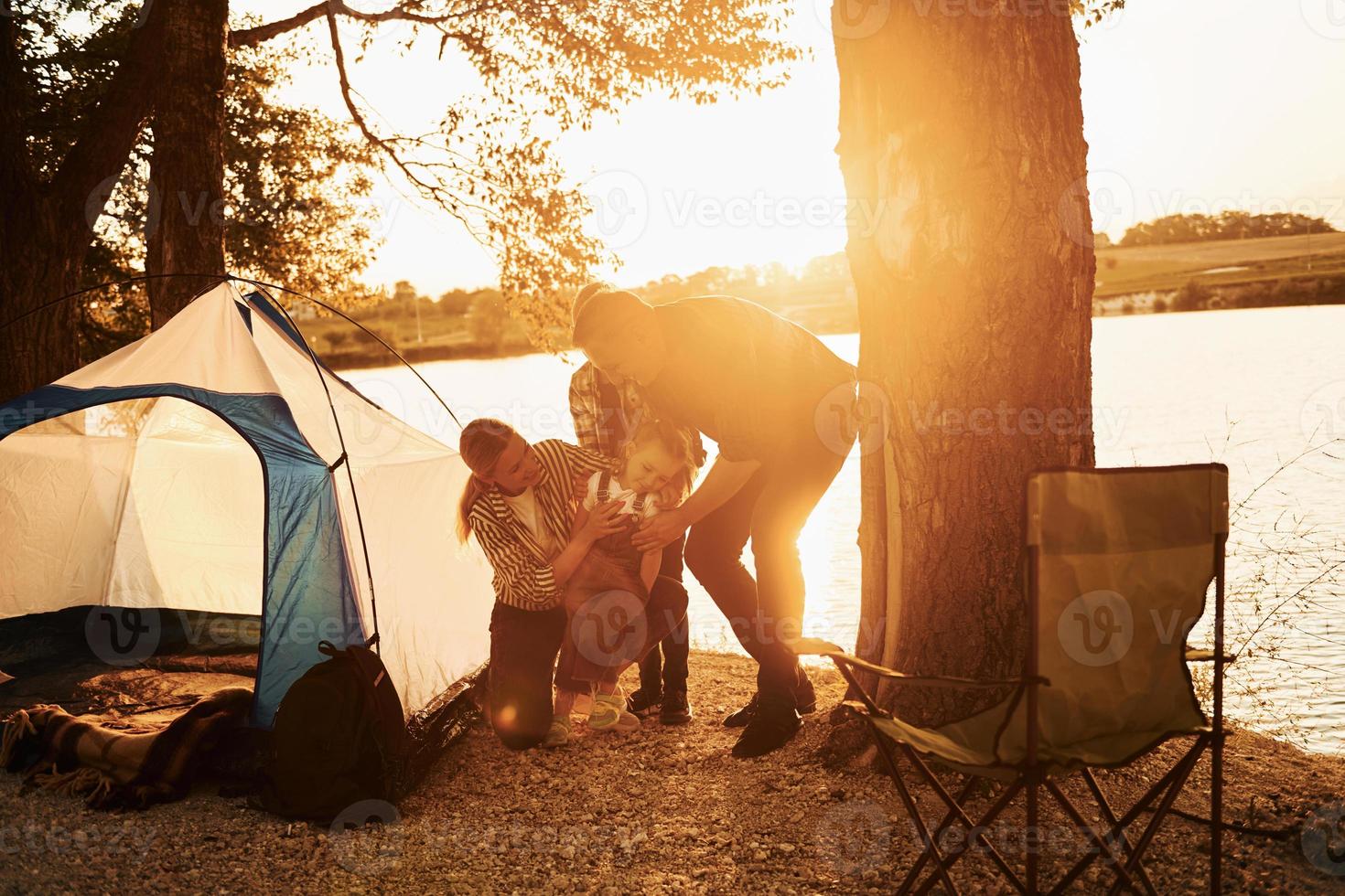 Active time spending. Family of mother, father and kids is on the camping photo