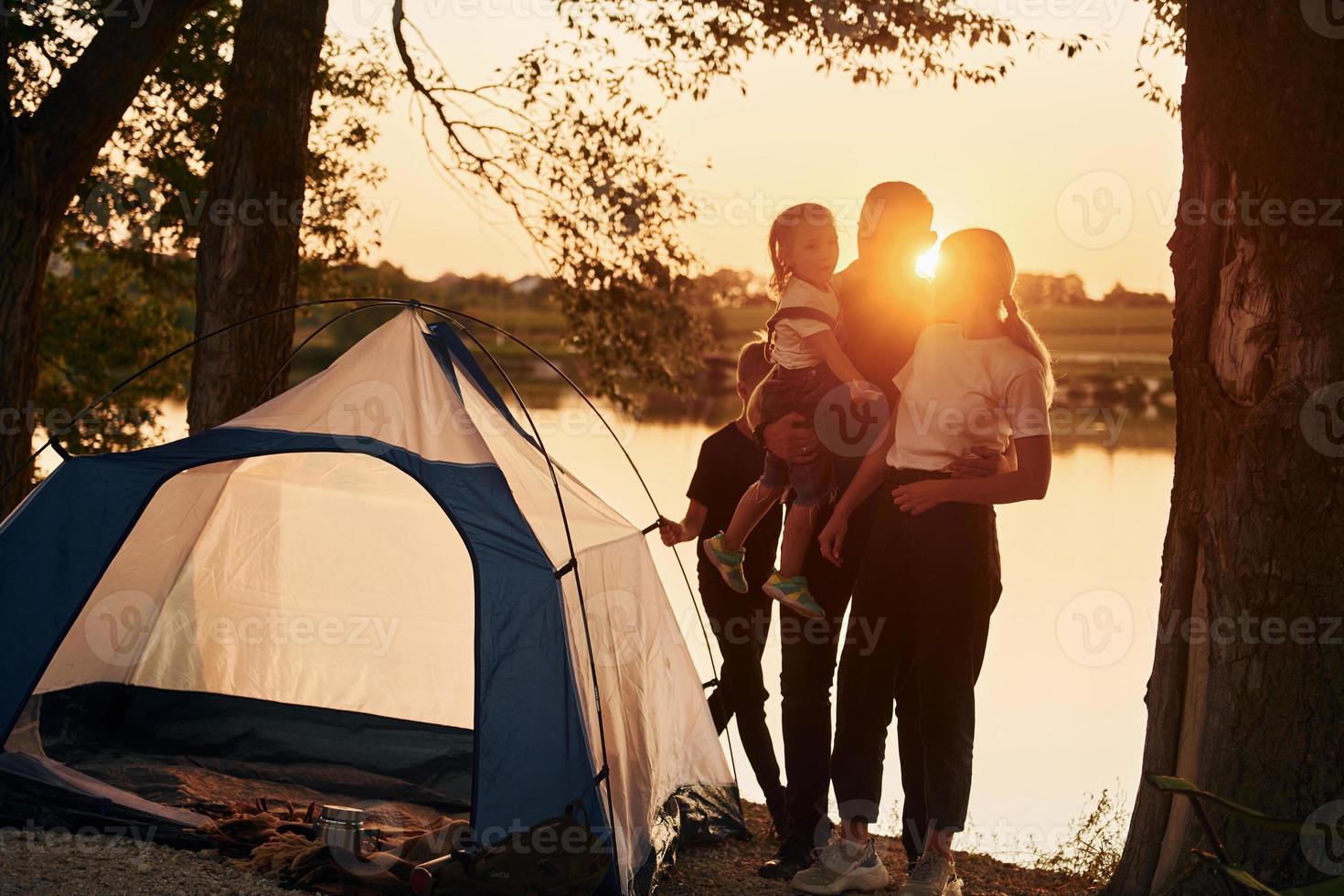 hora de la tarde la familia de madre, padre e hijos está acampando foto