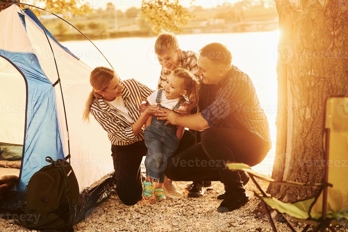 Beautiful sunlight. Family of mother, father and kids is on the camping photo