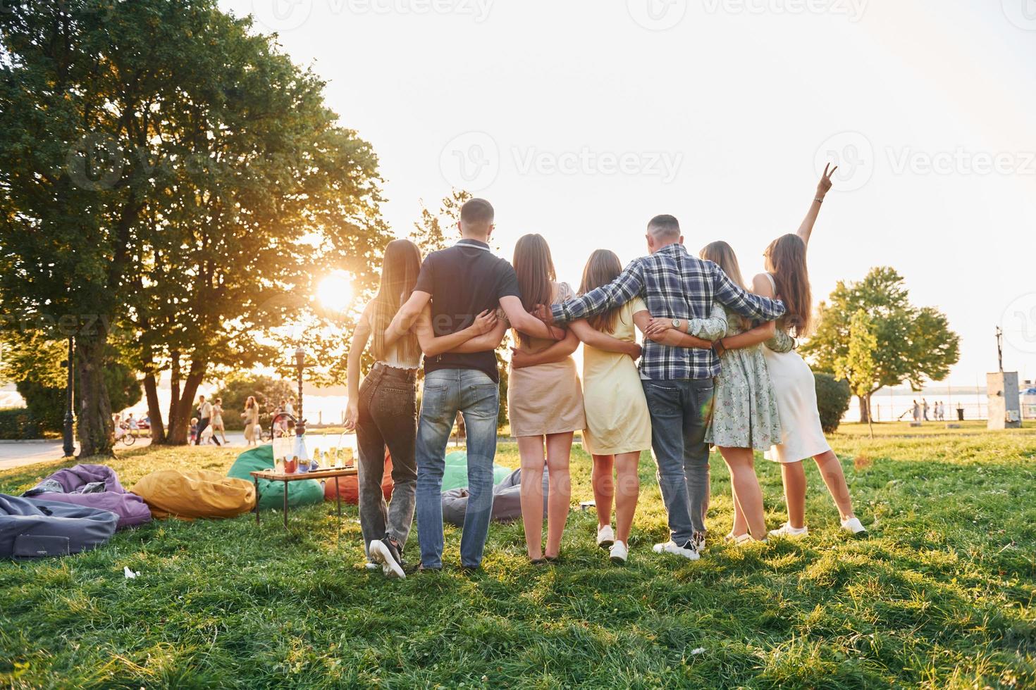 Group of young people have a party in the park at summer daytime photo