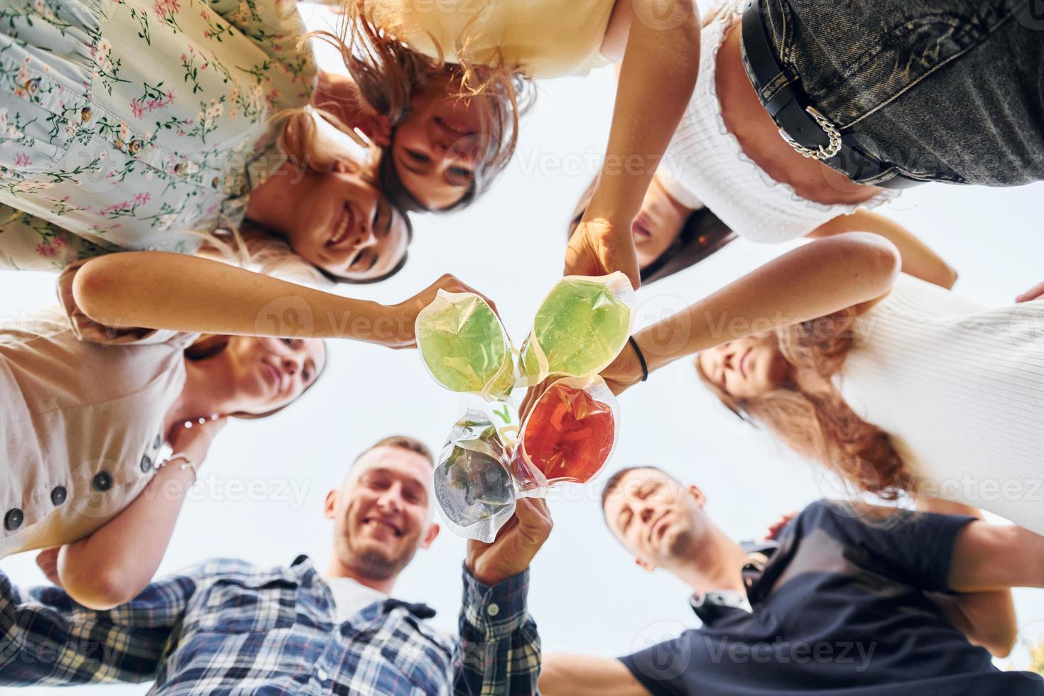 View from below of young positive people that looking down photo