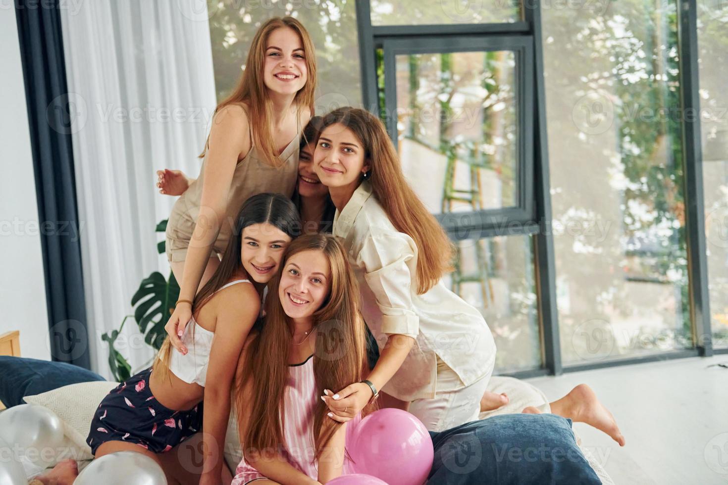 Having a rest on the bed. Group of happy women that is at a bachelorette party photo