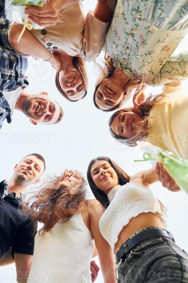 View from below of young positive people that looking down photo