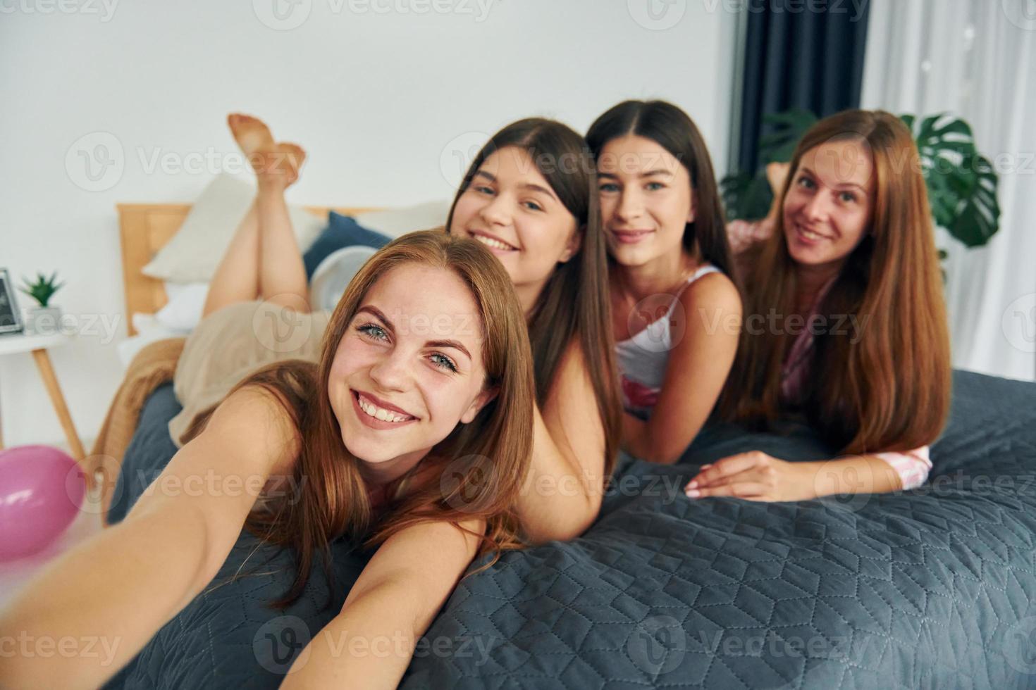 haciendo selfie usando el teléfono. grupo de mujeres felices que está en una despedida de soltera foto