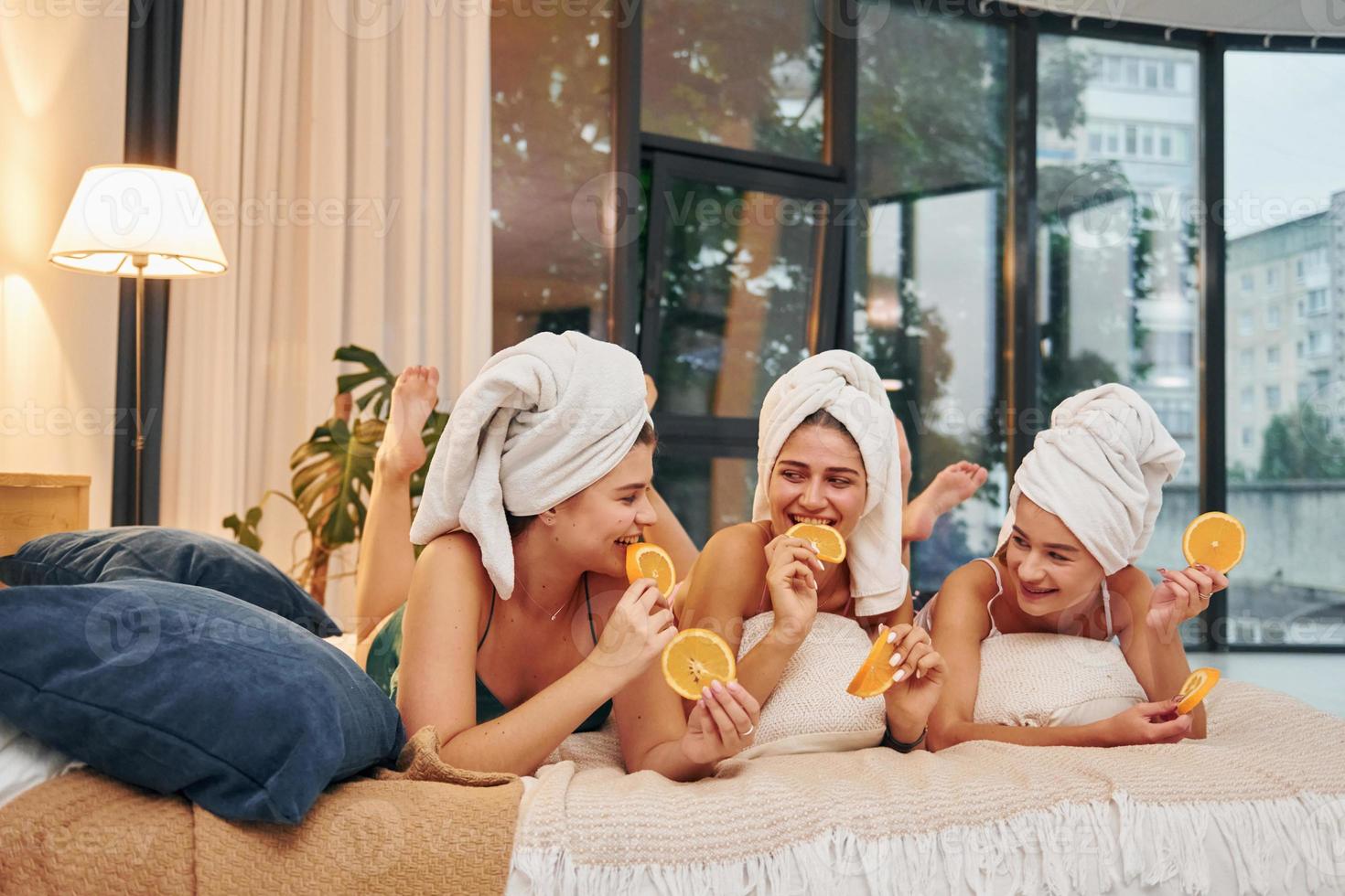 With slices of oranges. Group of happy women that is at a bachelorette party photo