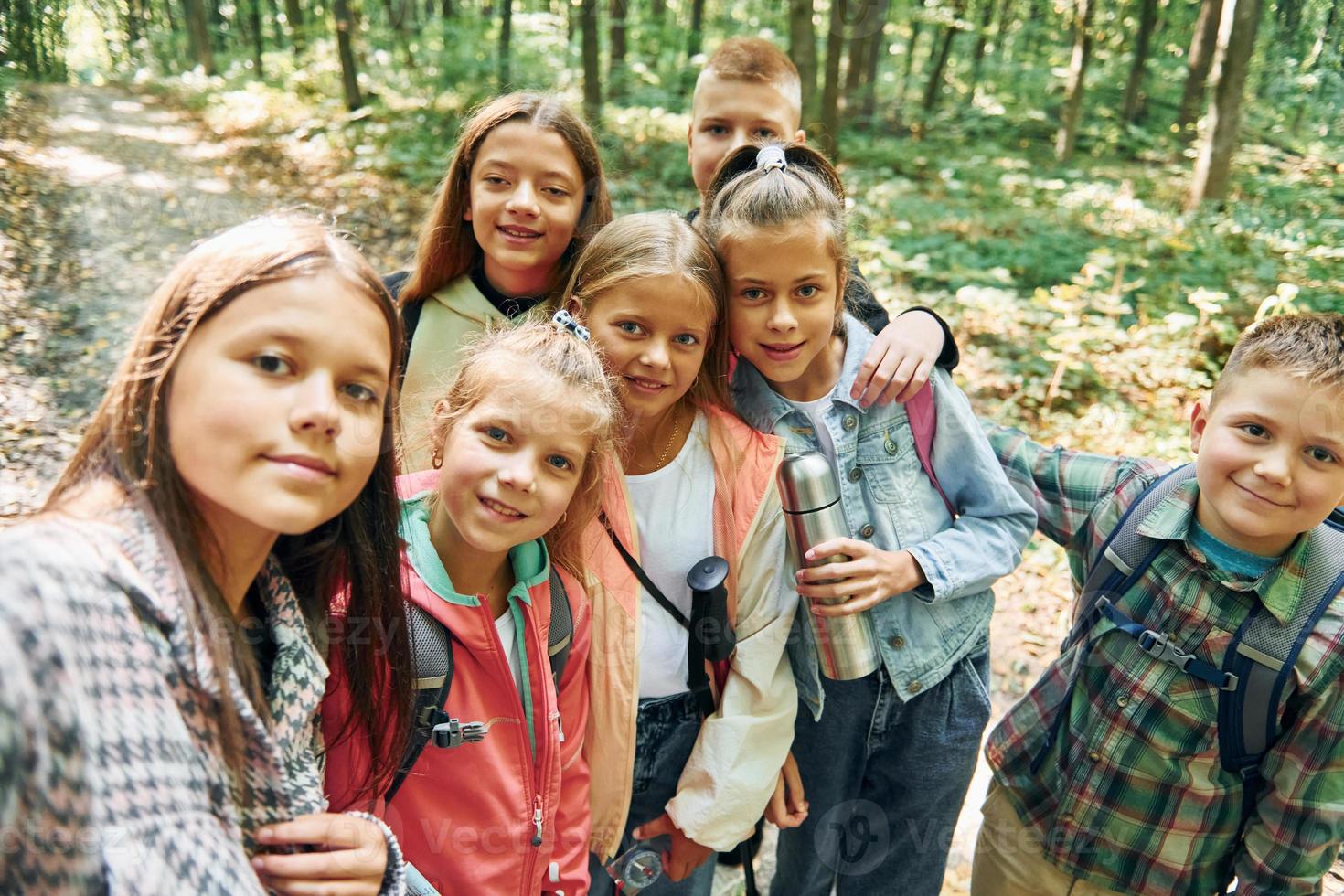 Making selfie. Kids in green forest at summer daytime together photo