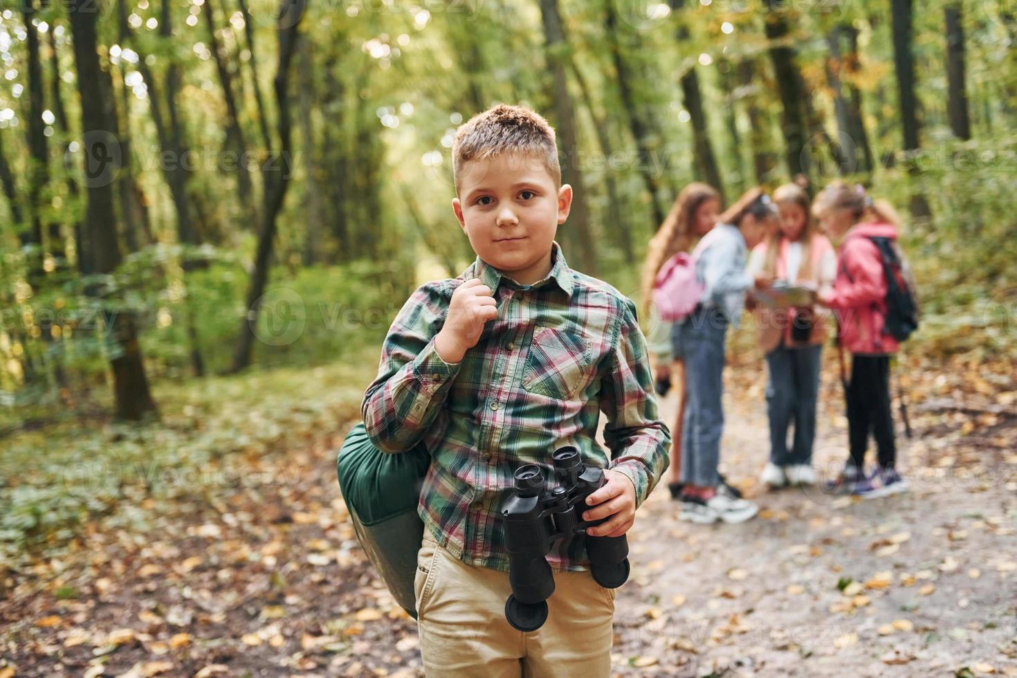 Conception of hiking. Kids in green forest at summer daytime together photo