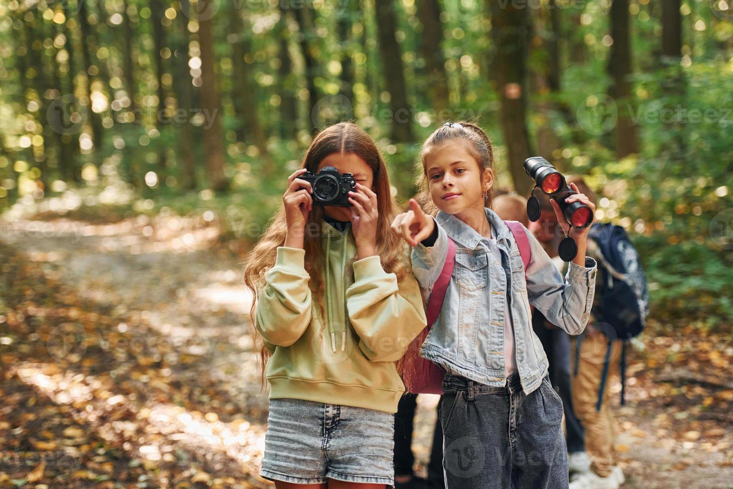 Two friends. Kids in green forest at summer daytime together photo
