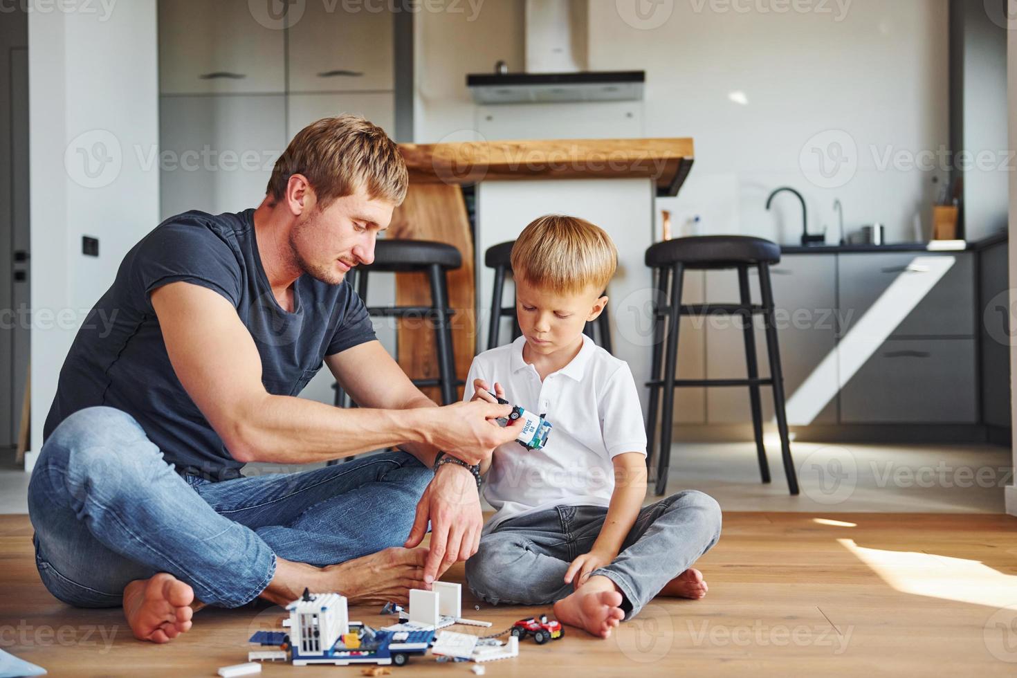 Playing with constructor. Father and son is indoors at home together photo