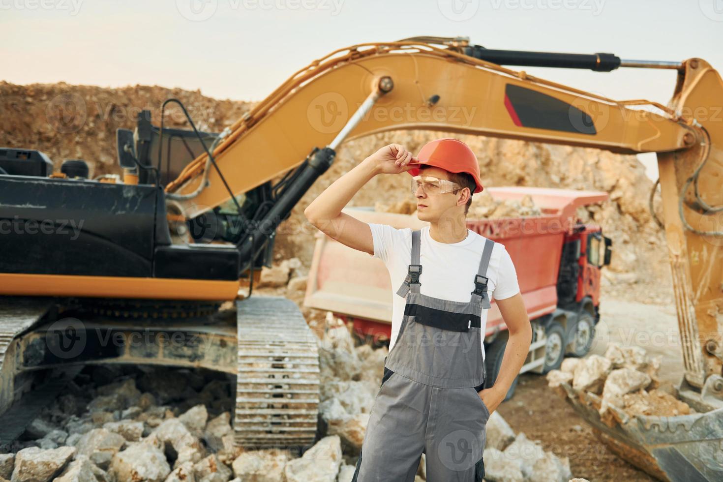 Portrait of worker in professional uniform that is on the borrow pit at daytime photo