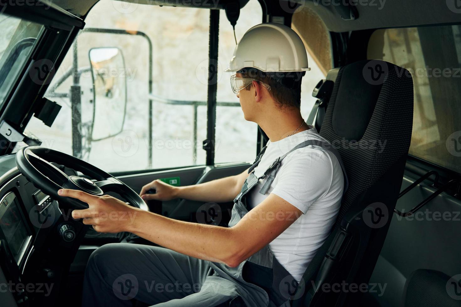 Driving transport. Worker in professional uniform is on the borrow pit at daytime photo