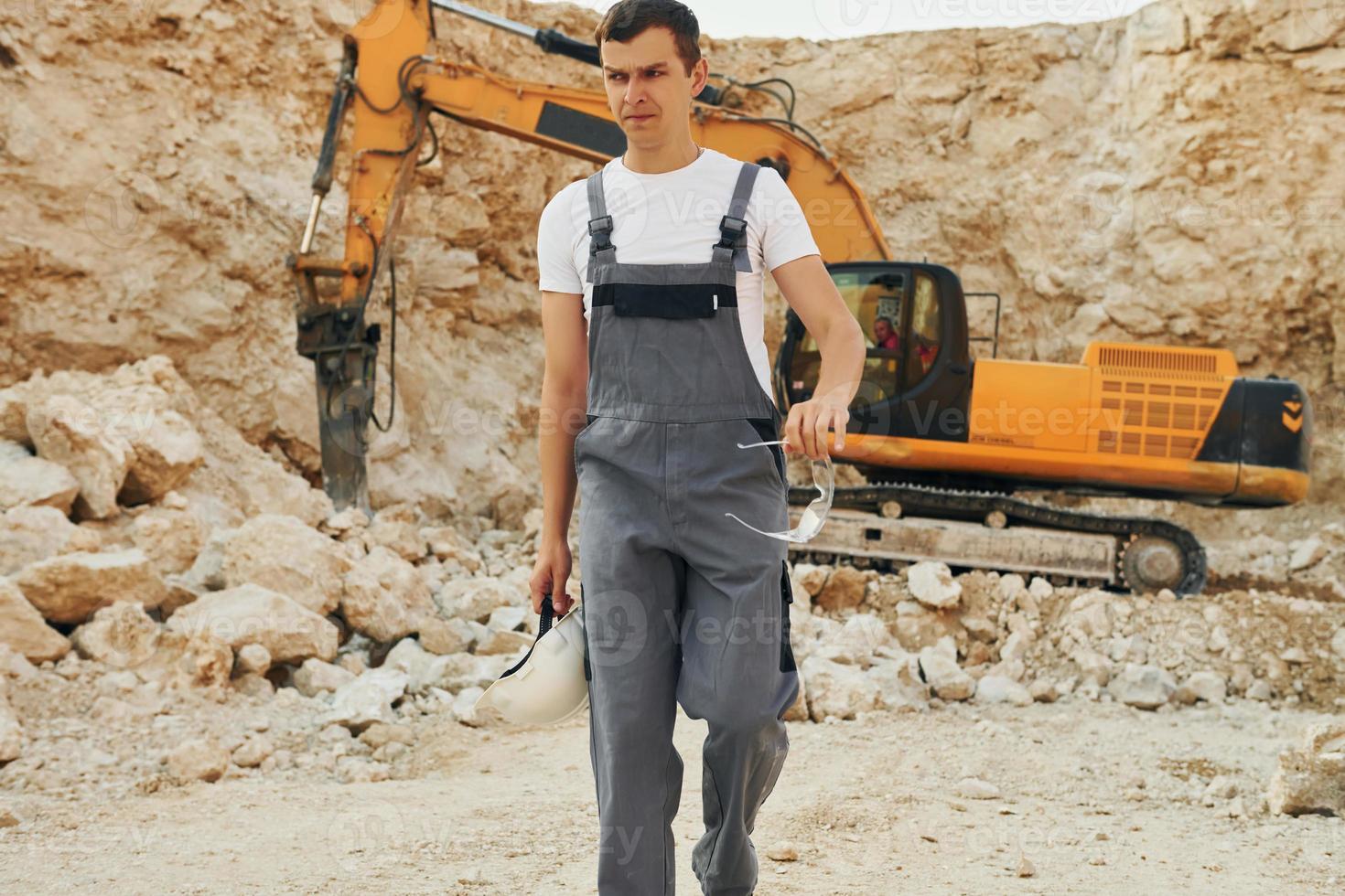 Operator is working on the borrow pit. Man in professional uniform photo