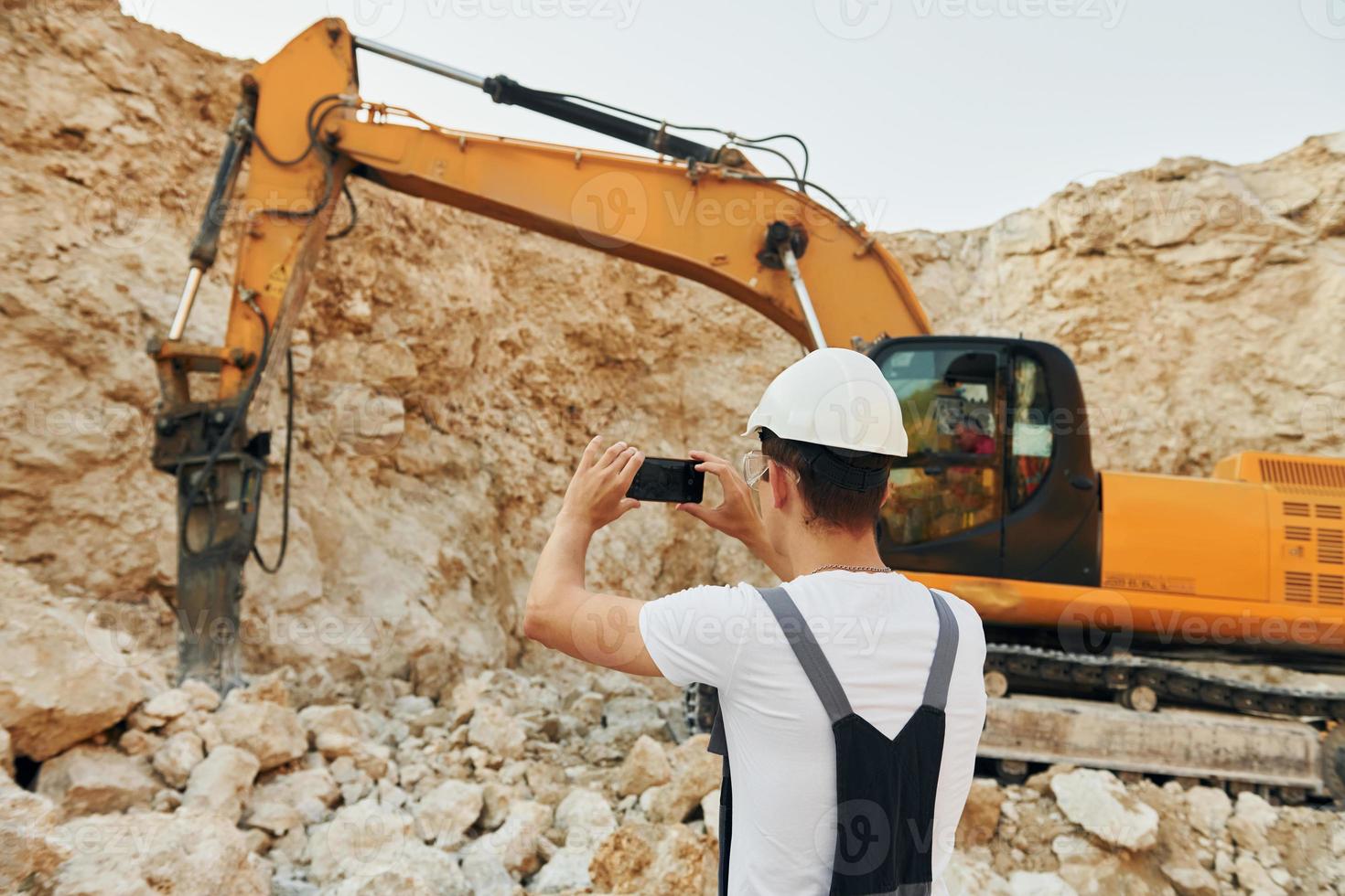 Big career. Worker in professional uniform is on the borrow pit at daytime photo