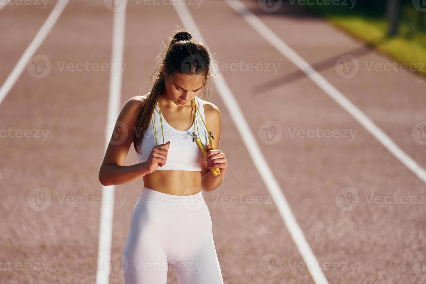 View from the front. Young woman in sportive clothes is exercising outdoors photo