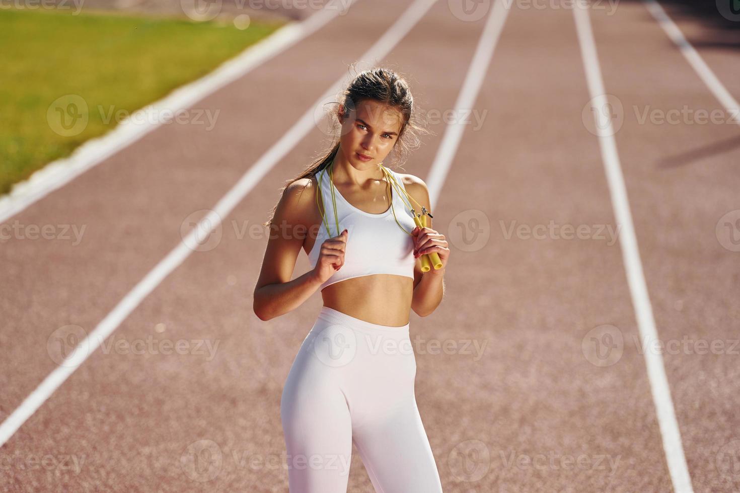 View from the front. Young woman in sportive clothes is exercising outdoors photo