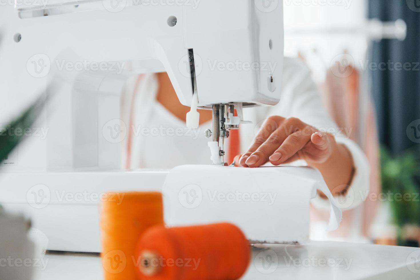 máquina de coser de color blanco. la costurera está en su oficina que está  con ropa diferente 15461656 Foto de stock en Vecteezy