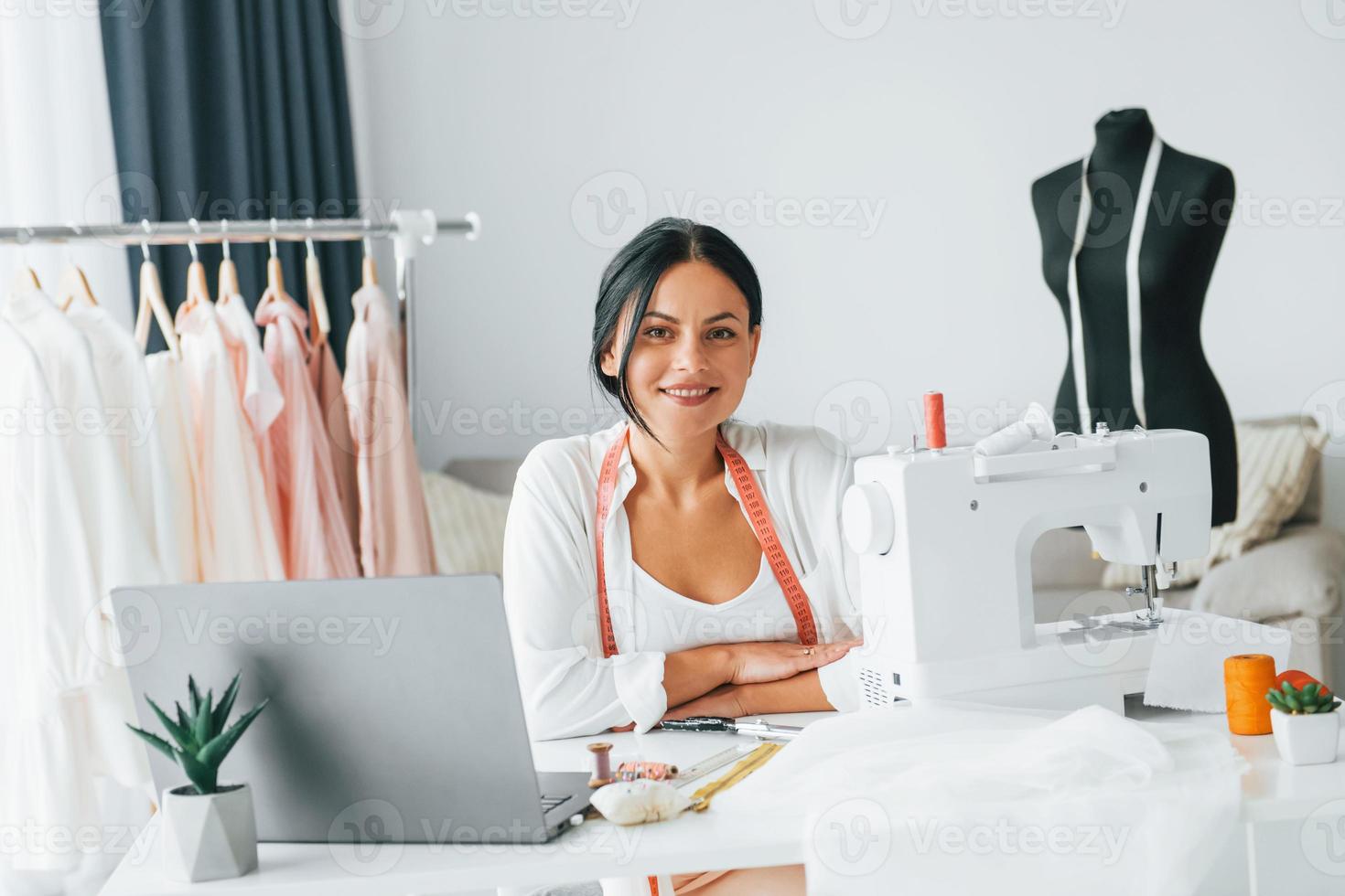 máquina de coser de color blanco. la costurera está en su oficina que está  con ropa diferente 15461656 Foto de stock en Vecteezy