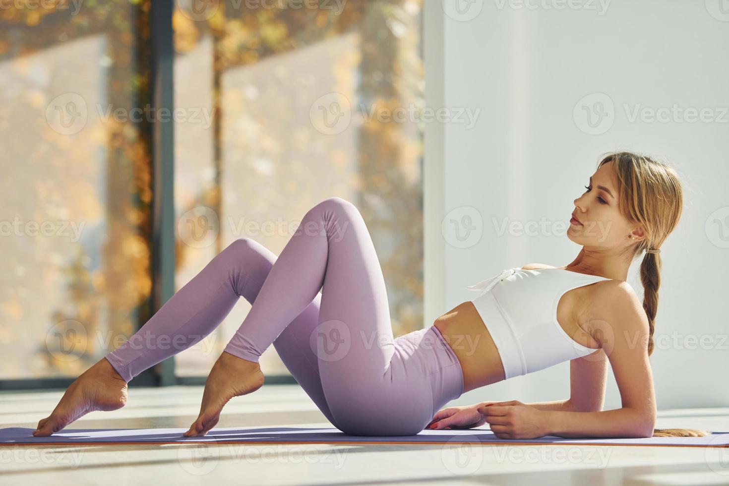 en el piso. mujer con ropa deportiva haciendo yoga en el interior 15462390  Foto de stock en Vecteezy