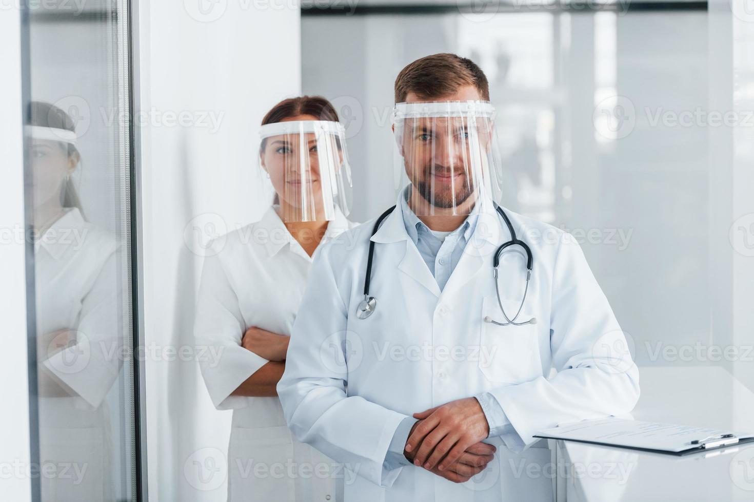 Front view. Two doctors in white coats is in the clinic working together photo